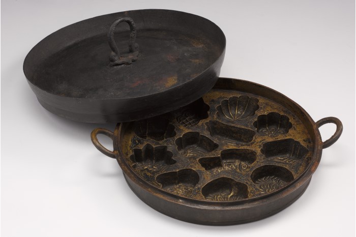<strong><em>Kueh bahulu</em> mould and lid</strong><br>
1950s <br>
Metal <br>
Collection of the National Museum of Singapore